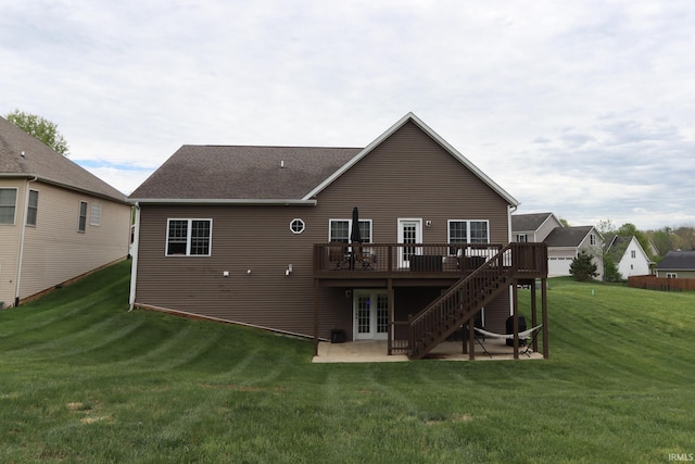 rear view of property featuring french doors, a wooden deck, a yard, a patio, and a shingled roof