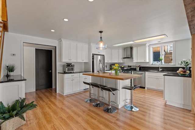 15860 Cook Lake Trl, Plymouth, IN 46563 - kitchen featuring a sink, wooden counters, light wood-style flooring, wall chimney exhaust hood, and stainless steel appliances