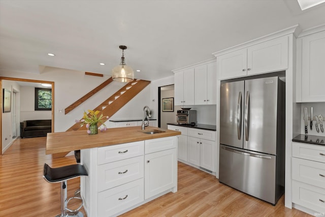 15860 Cook Lake Trl, Plymouth, IN 46563 - kitchen featuring white cabinets, a sink, light wood finished floors, wood counters, and freestanding refrigerator
