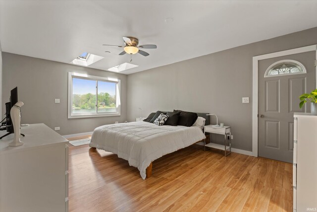 15860 Cook Lake Trl, Plymouth, IN 46563 - bedroom featuring a skylight, multiple windows, baseboards, and light wood-style floors