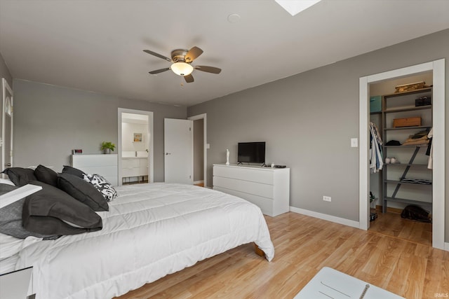 15860 Cook Lake Trl, Plymouth, IN 46563 - bedroom featuring a walk in closet, light wood-style flooring, a ceiling fan, baseboards, and a closet