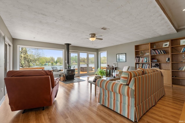 15860 Cook Lake Trl, Plymouth, IN 46563 - living area with plenty of natural light, a wood stove, wood finished floors, and visible vents