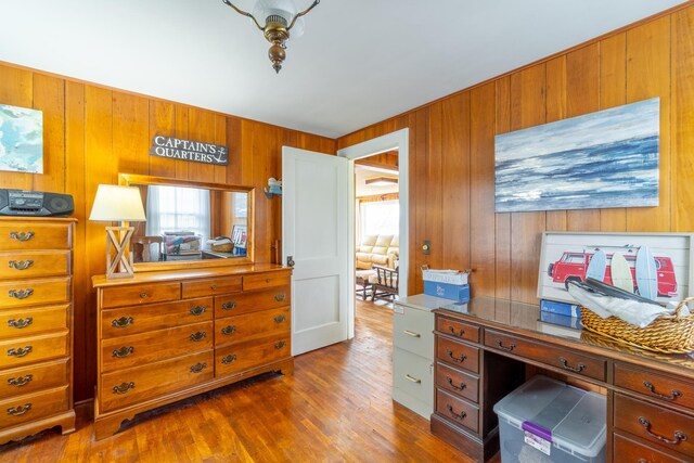 office area with wooden walls, dark wood-style flooring, and a wealth of natural light