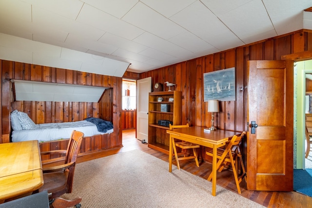 bedroom with wood walls and wood finished floors