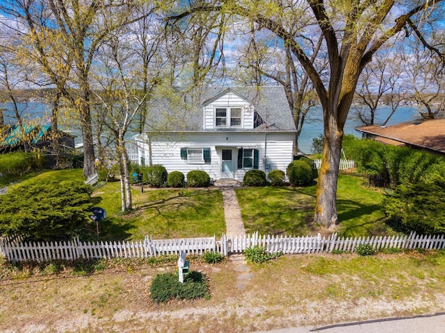 new england style home with a fenced front yard and a front yard