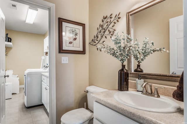 bathroom featuring vanity, tile patterned flooring, visible vents, toilet, and washer / clothes dryer