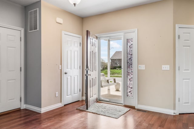entryway featuring baseboards, visible vents, and wood finished floors