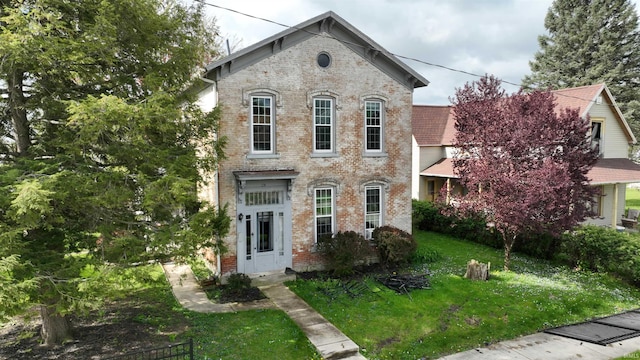 italianate home featuring a front yard and brick siding