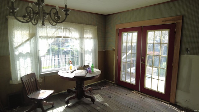 dining space with wood-type flooring, french doors, and a chandelier
