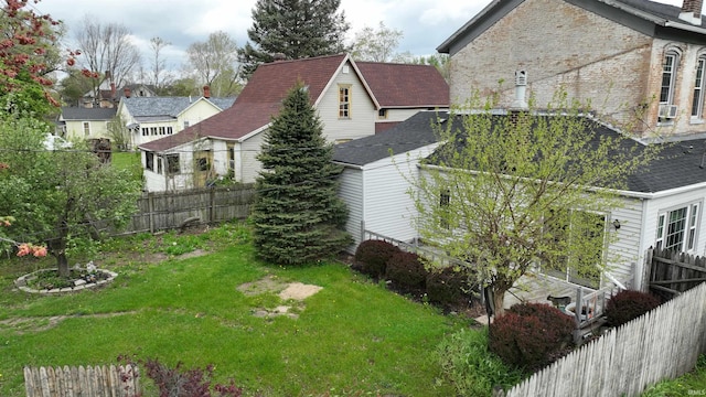 view of side of home with fence and a lawn