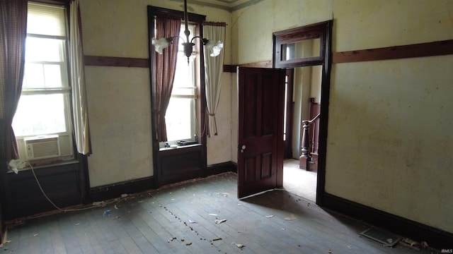 spare room featuring cooling unit and hardwood / wood-style floors