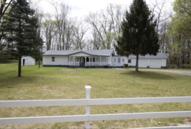 ranch-style home with covered porch, a fenced front yard, and a front yard