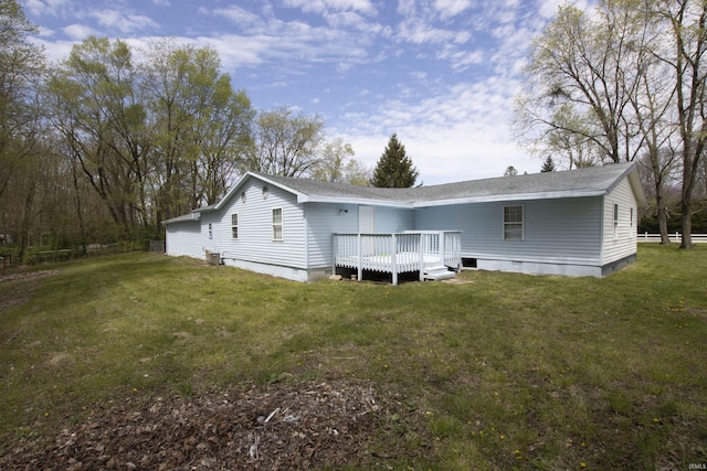 back of property featuring a yard, a deck, crawl space, and a shingled roof