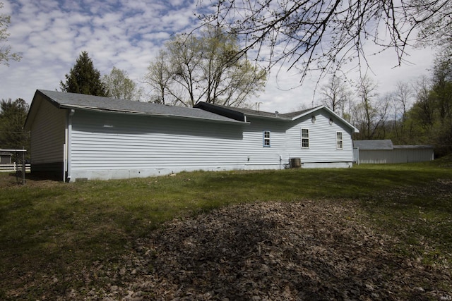 back of house featuring a shingled roof, a yard, and cooling unit