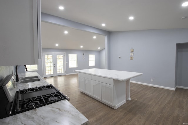 kitchen with french doors, dark wood finished floors, a sink, baseboards, and white cabinets