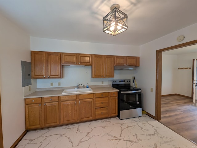 kitchen with brown cabinetry, electric panel, stainless steel electric range, a sink, and light countertops