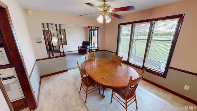 dining area with ceiling fan, plenty of natural light, and baseboards