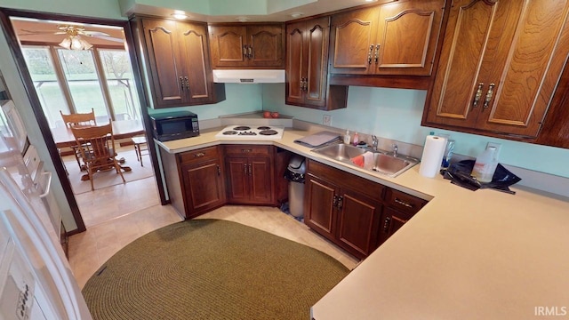 kitchen featuring a sink, light countertops, black microwave, and white electric stovetop