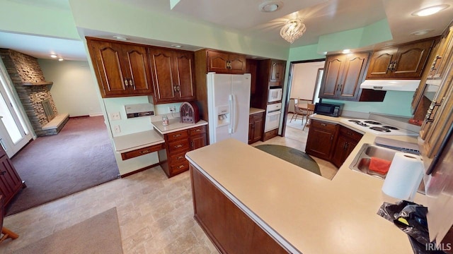 kitchen with light countertops, under cabinet range hood, light carpet, and white appliances