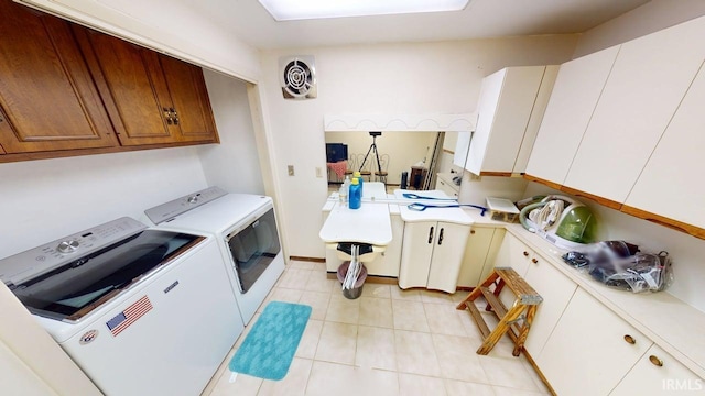 clothes washing area featuring light tile patterned floors, visible vents, cabinet space, and washer and clothes dryer