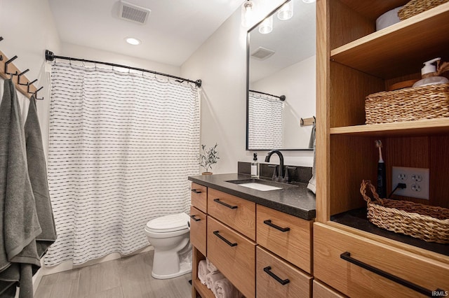 bathroom featuring recessed lighting, vanity, toilet, and visible vents