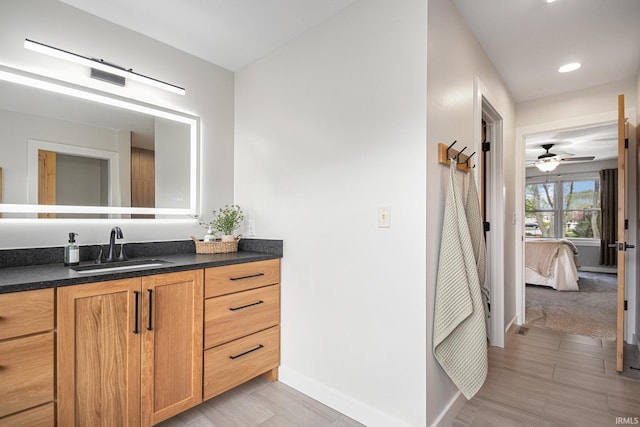 ensuite bathroom with vanity, baseboards, ensuite bathroom, recessed lighting, and a ceiling fan