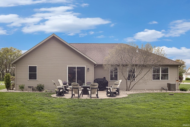 rear view of house featuring a shingled roof, a patio area, central air condition unit, and a yard