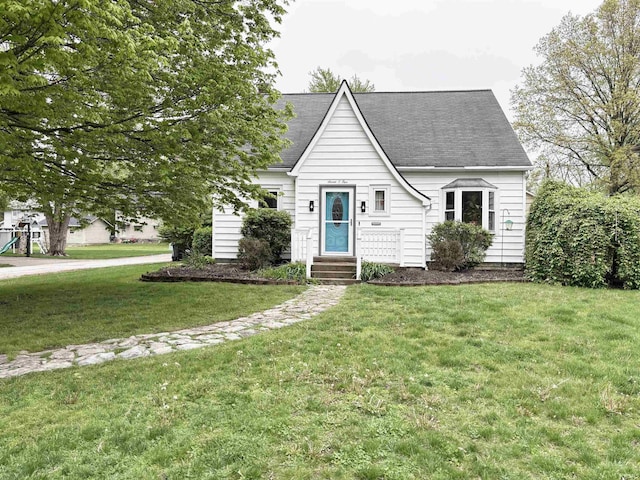 705 Lehman St, Berne, IN 46711 - new england style home featuring roof with shingles and a front lawn