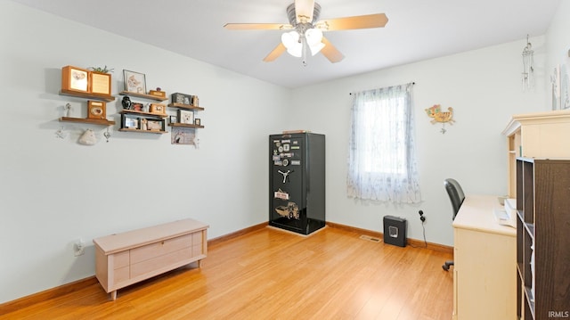 office space with a ceiling fan, baseboards, visible vents, and light wood-type flooring