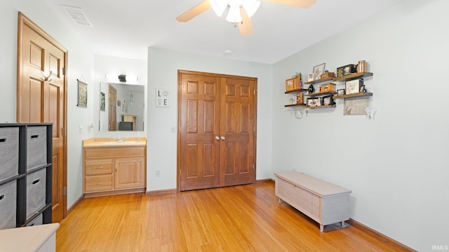 bedroom with visible vents, connected bathroom, light wood-style floors, and baseboards
