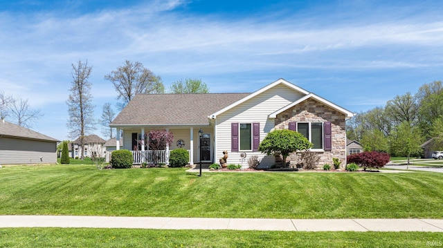 view of front facade featuring a porch, a shingled roof, stone siding, and a front lawn