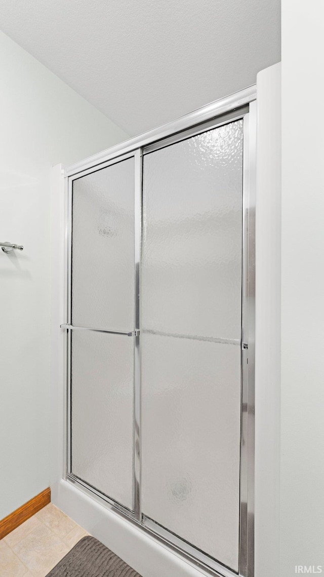 bathroom featuring baseboards and an enclosed shower