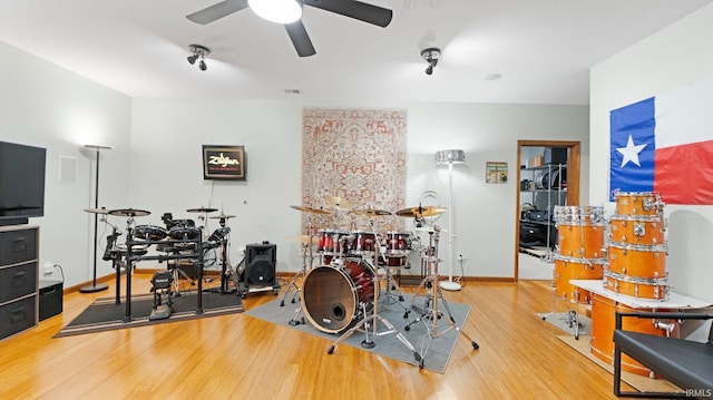 rec room with baseboards, a ceiling fan, wood finished floors, and visible vents