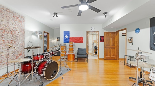 interior space featuring a ceiling fan, visible vents, and wood finished floors
