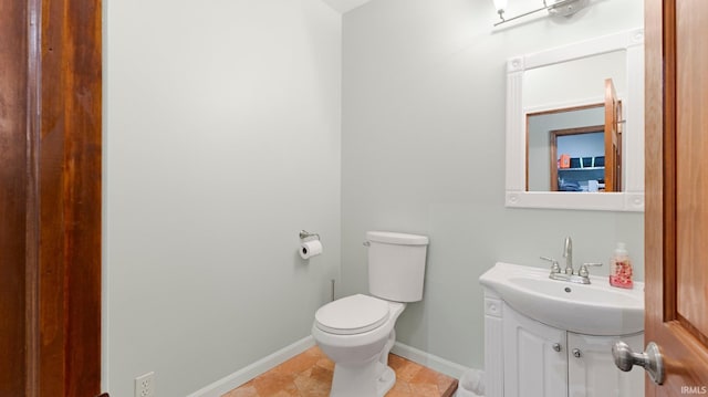 bathroom featuring vanity, baseboards, tile patterned floors, and toilet