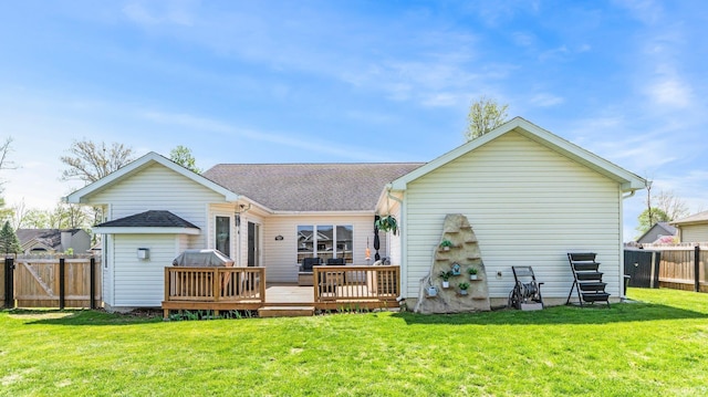 back of house with a fenced backyard, a shingled roof, a lawn, and a deck