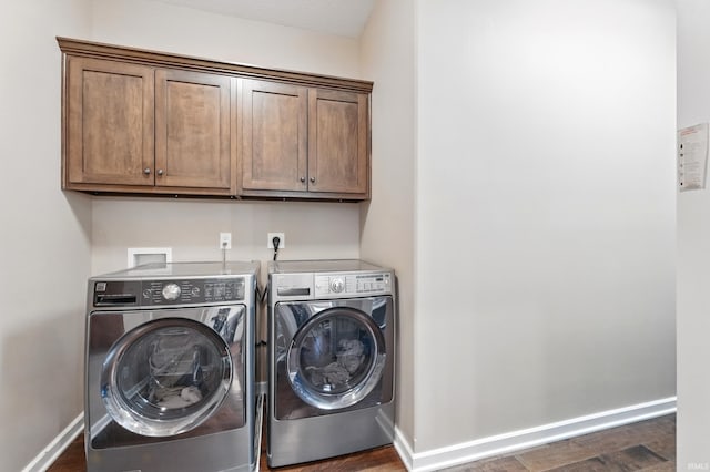 laundry area with independent washer and dryer, cabinet space, baseboards, and dark wood-type flooring