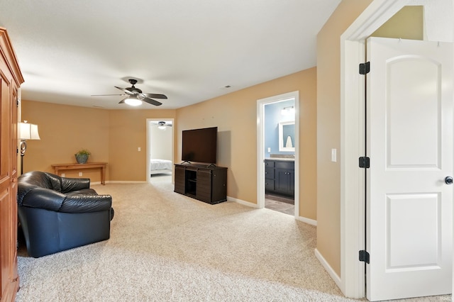 living area with ceiling fan, carpet floors, and baseboards