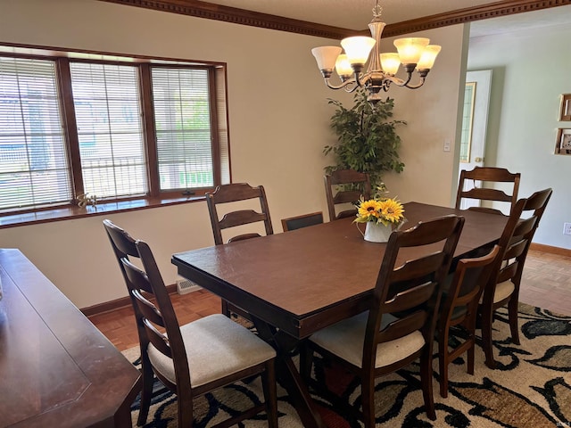 dining space with baseboards, a notable chandelier, and crown molding