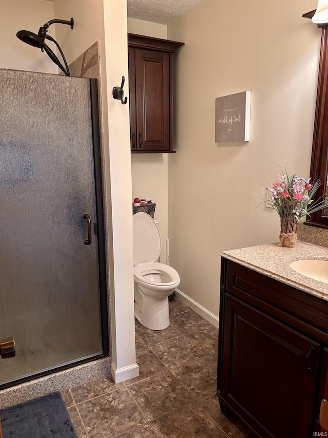 bathroom with toilet, vanity, tile patterned floors, a shower stall, and baseboards