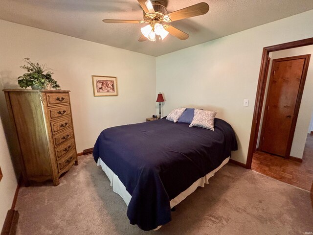 carpeted bedroom featuring ceiling fan and baseboards