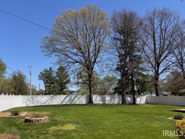 view of yard with an outdoor fire pit and fence
