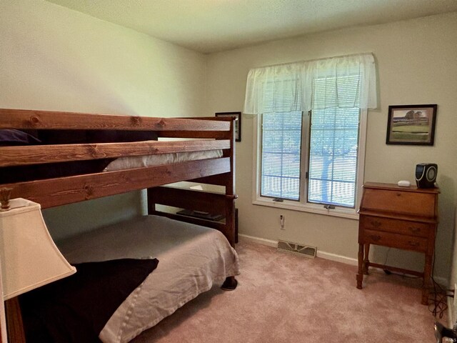 bedroom featuring light colored carpet, baseboards, and visible vents