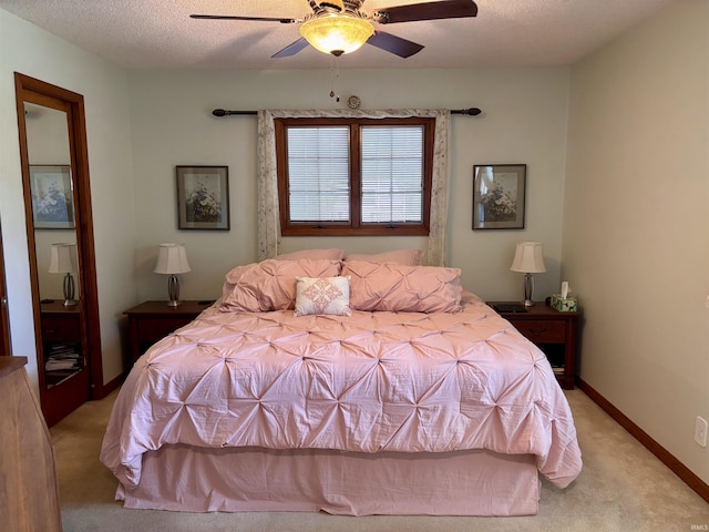 bedroom with a textured ceiling, baseboards, a ceiling fan, and light colored carpet