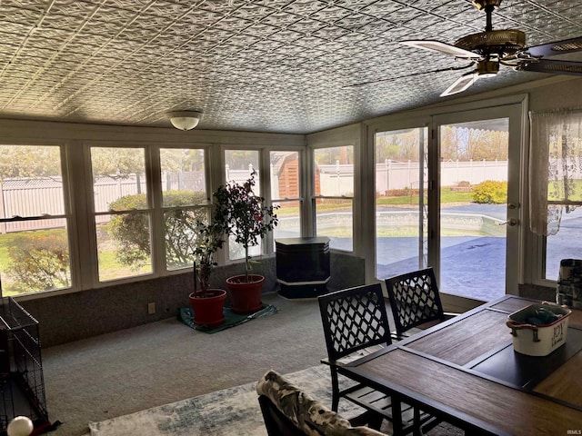 sunroom / solarium featuring a ceiling fan, an ornate ceiling, and a healthy amount of sunlight