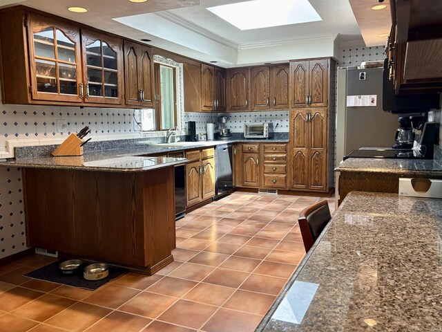 kitchen featuring glass insert cabinets, dishwasher, light tile patterned flooring, a peninsula, and a skylight