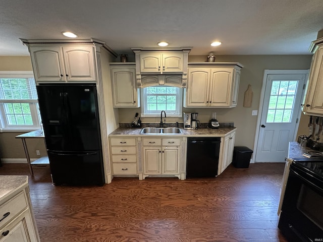 kitchen with recessed lighting, dark wood finished floors, black appliances, and a sink