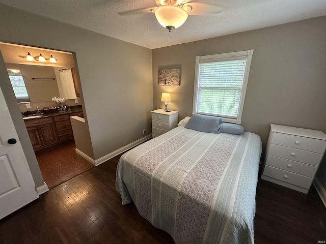bedroom featuring multiple windows, ensuite bathroom, dark wood finished floors, and ceiling fan