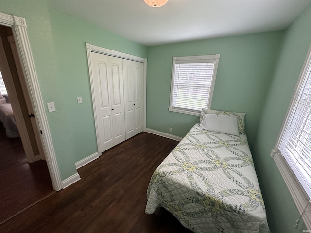 bedroom featuring baseboards, dark wood-style floors, and a closet