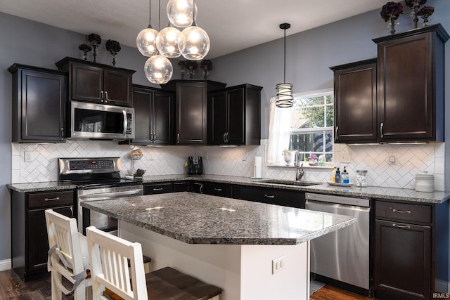 5138 Indigo Ave, Lafayette, IN 47909 - kitchen featuring a sink, a kitchen bar, dark stone counters, and appliances with stainless steel finishes